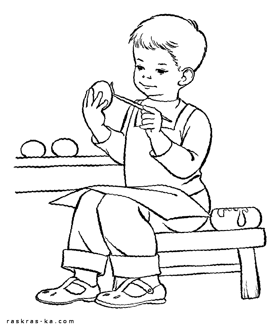 Мальчик красит пасхальные яйца перед праздником